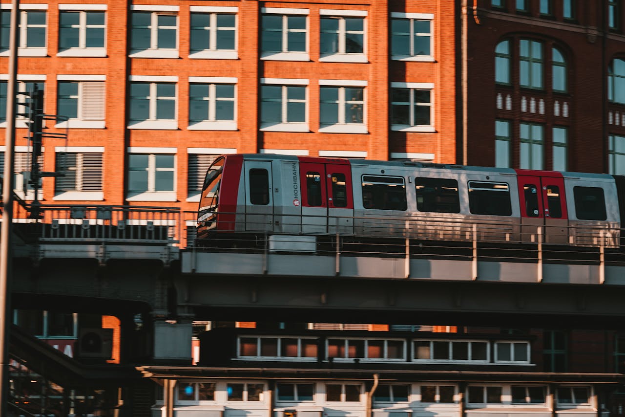 White and Red Train Near Brown Concrete Building